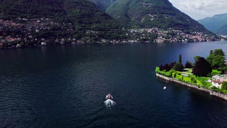 Seguimiento-Aéreo-De-Una-Pequeña-Lancha-Turística-En-El-Lago-Como,-Italia