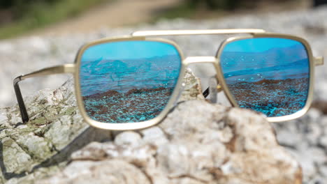 Mirrored-sunglasses-on-a-beach