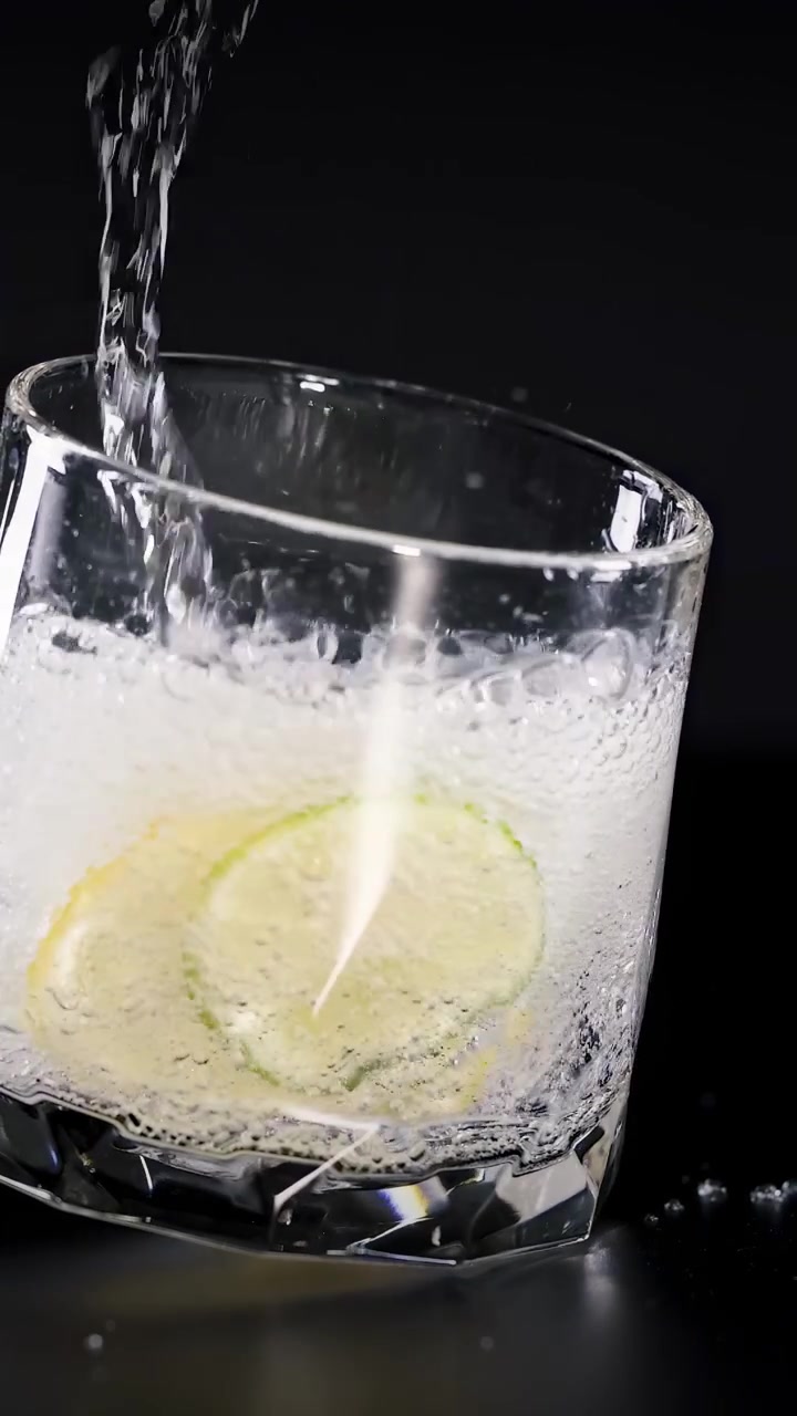 Soda versata in un bicchiere con limone e ghiaccio