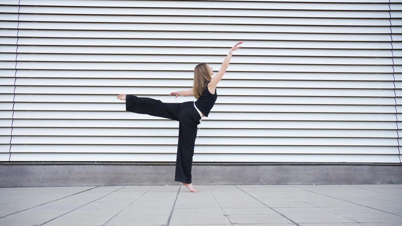Movimenti di danza dinamici eseguiti su uno sfondo con un motivo a linee suggestivo creano un'intrigo visivo.