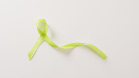 Video-of-pale-green-std-awareness-ribbon-on-white-background-with-copy-space