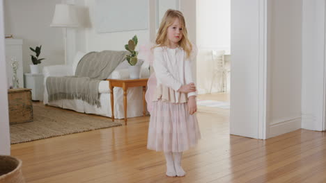 shy little girl playing dress up wearing fairy wings ballet costume pretending to be ballerina at home 4k