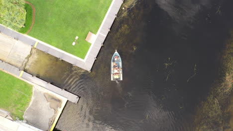 a top down shot over a boat in a canal on a cloudy day