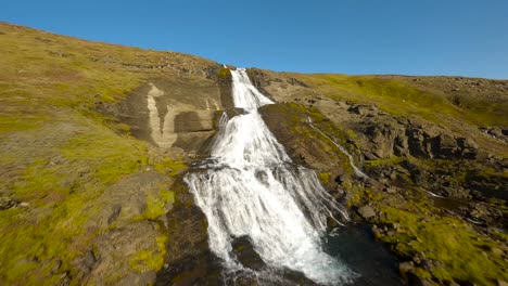 fpv aerial footage of the large glymor waterfall, flying upwards stream in scenic landcape, iceland