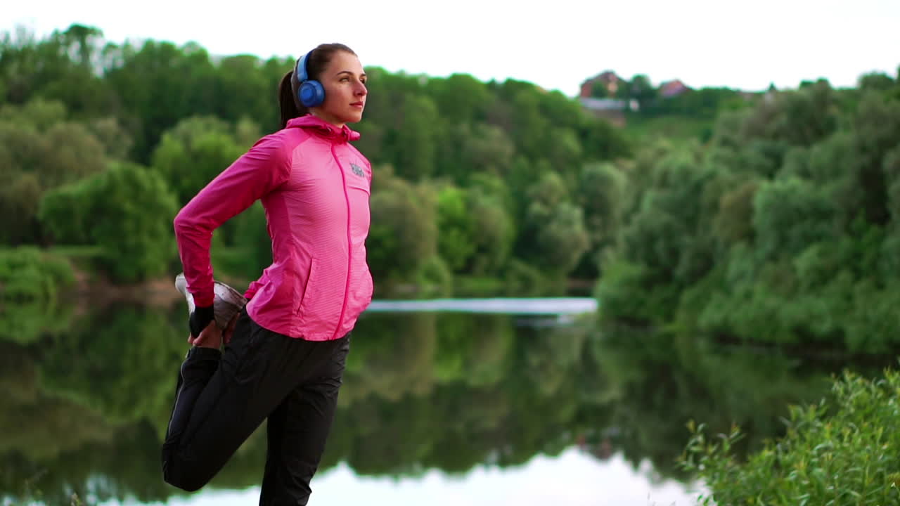 The girl warms up early in the morning before training preparing for a run in the sun