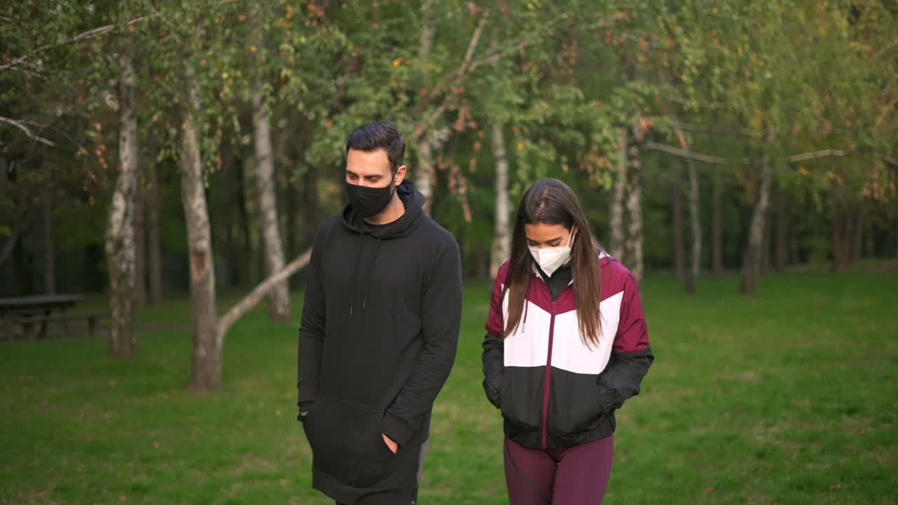 Couple wearing face masks walking in a park
