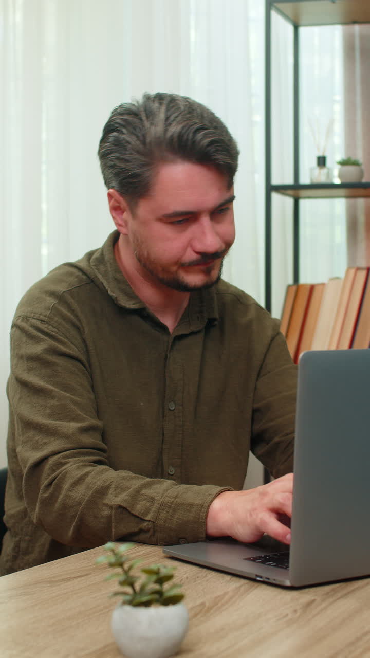 Middleaged man rubs neck closing laptop annoyed pain posture fatigue after lengthy desk work table