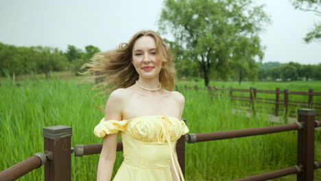 una mujer rubia muy bonita posando sonriendo con una mirada seductora en el campo