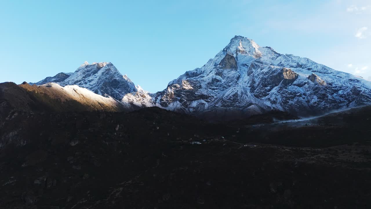 Towering Himalayan mountains frame the Everest Base Camp trekking route in Nepal, where trekkers experience breathtaking vistas of the world’s highest peaks along their high-altitude journey.