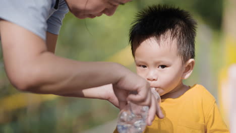 Asiatisches-Kind-Trinkt-Wasser-Aus-Der-Flasche