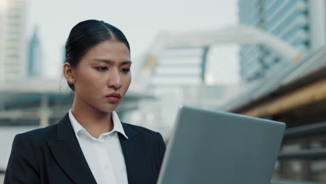 business woman working on a laptop in a city