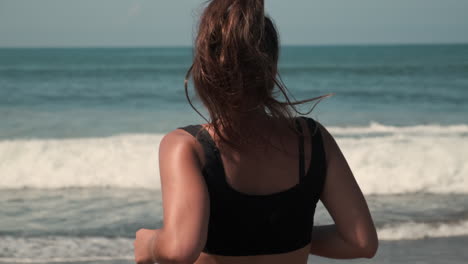 una mujer en una playa mirando al océano.