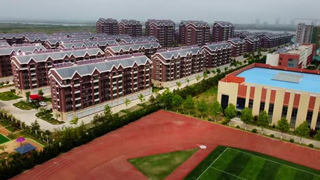 aerial view of an urbanized residential complex with a football field in nanhai new district, china