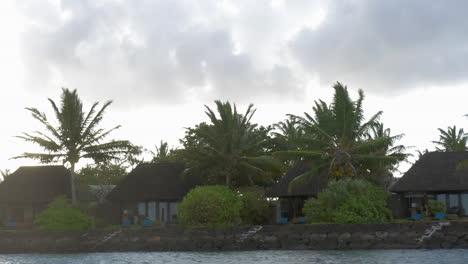 vista de moverse a lo largo de la costa con hotel de bungalow de lujo contra el cielo nublado isla de mauricio
