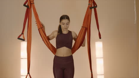 Mädchen-Wärmt-Körper-In-Hängematte-Im-Studio.-Dame,-Die-Drinnen-Fliegenyoga-Praktiziert