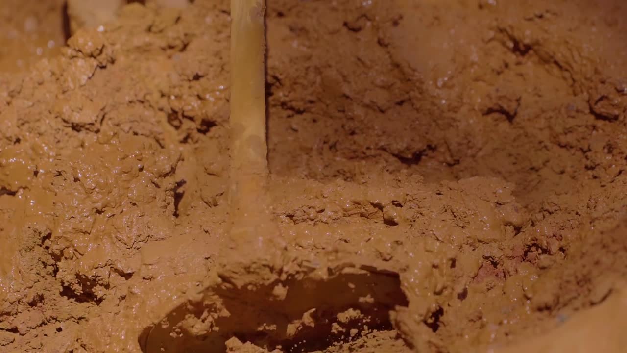 Bygningsarbejder blander jord for at lave adobe-mursten ved hjælp af en bæredygtig og traditionel byggemetode i Chapada dos Veadeiros, Brasilien, som en form for kulturel modstand i slowmotion