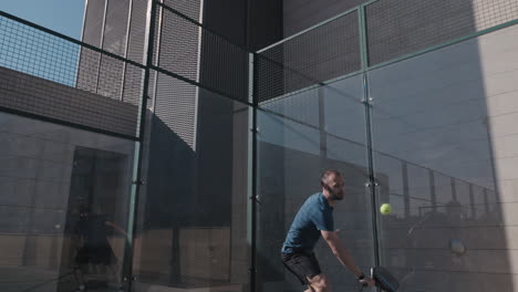 El-Jugador-De-Pádel-Hace-Un-Tiro-Alto-Después-De-Que-La-Pelota-Golpea-La-Pared-Trasera