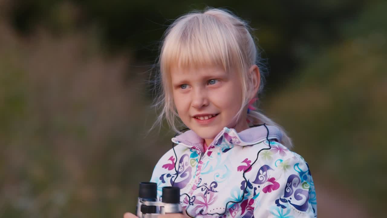 un niño alegre mira a través de binoculares 1