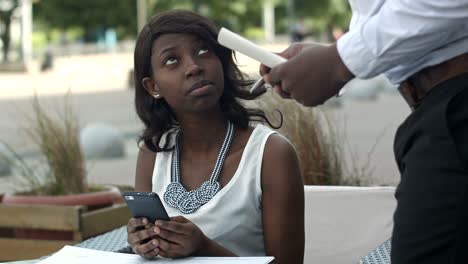 beautiful afro american woman ordering from menu in restaurant and deciding what to eat