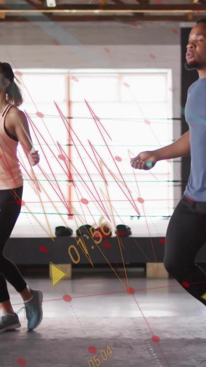 Vertical video: Woman and man starting rope swing, doing jump-rope fitness in gym, showing graphics