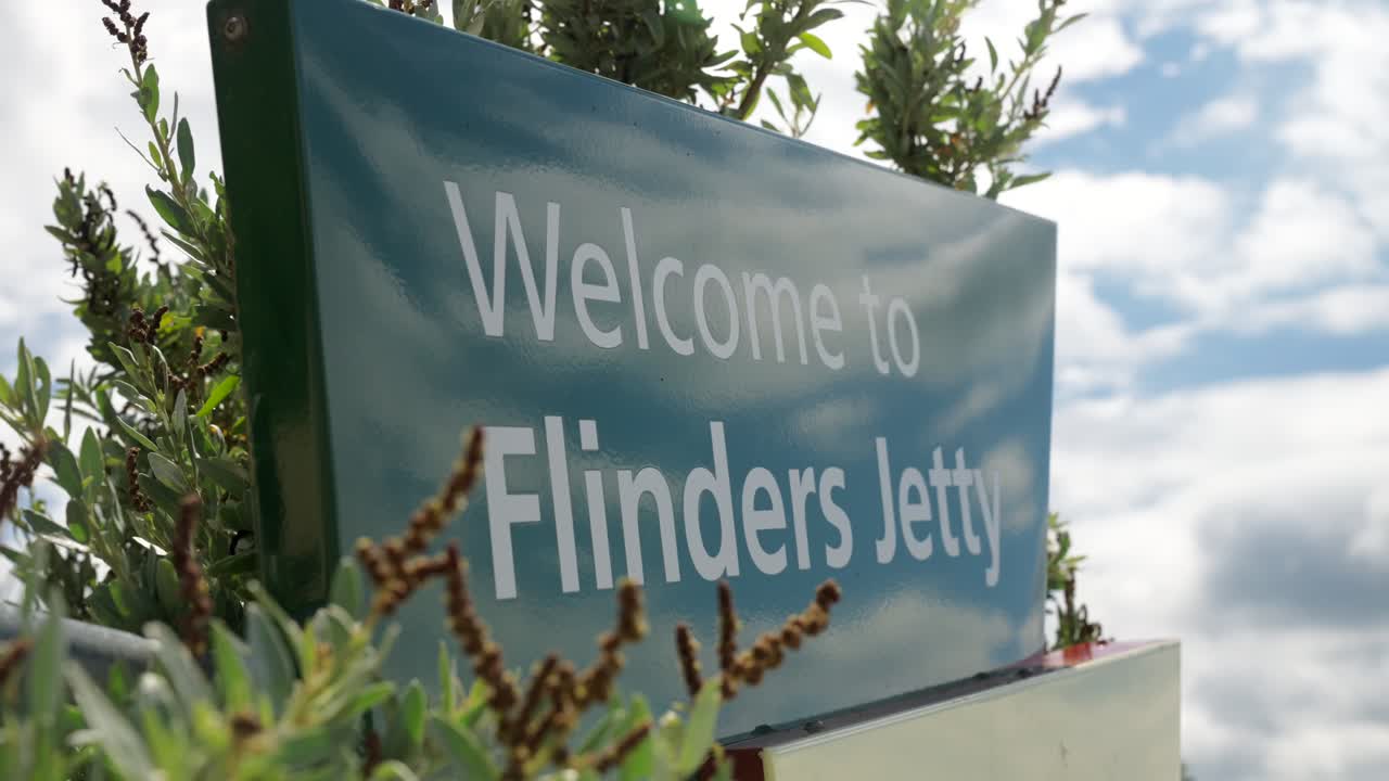 A welcoming shot of the Flinders Jetty, with calm waters and the stunning coastline, evoking a peaceful, picturesque atmosphere perfect for travel and exploration.