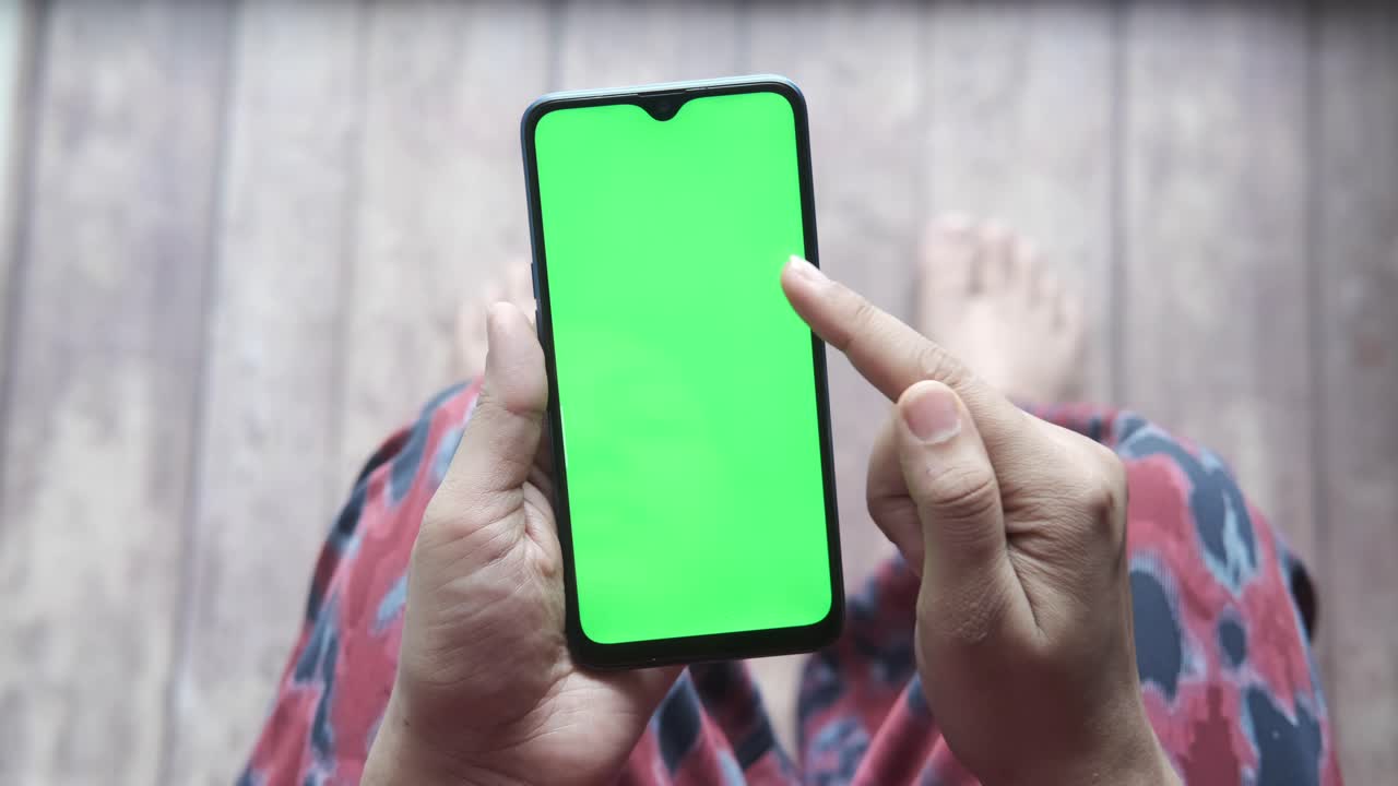 persona que utiliza un teléfono inteligente con una pantalla verde