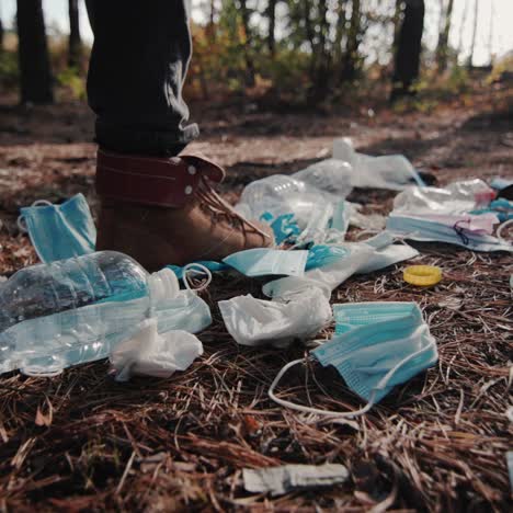 a man walks through the woods past a landfill made of household rubbish 1