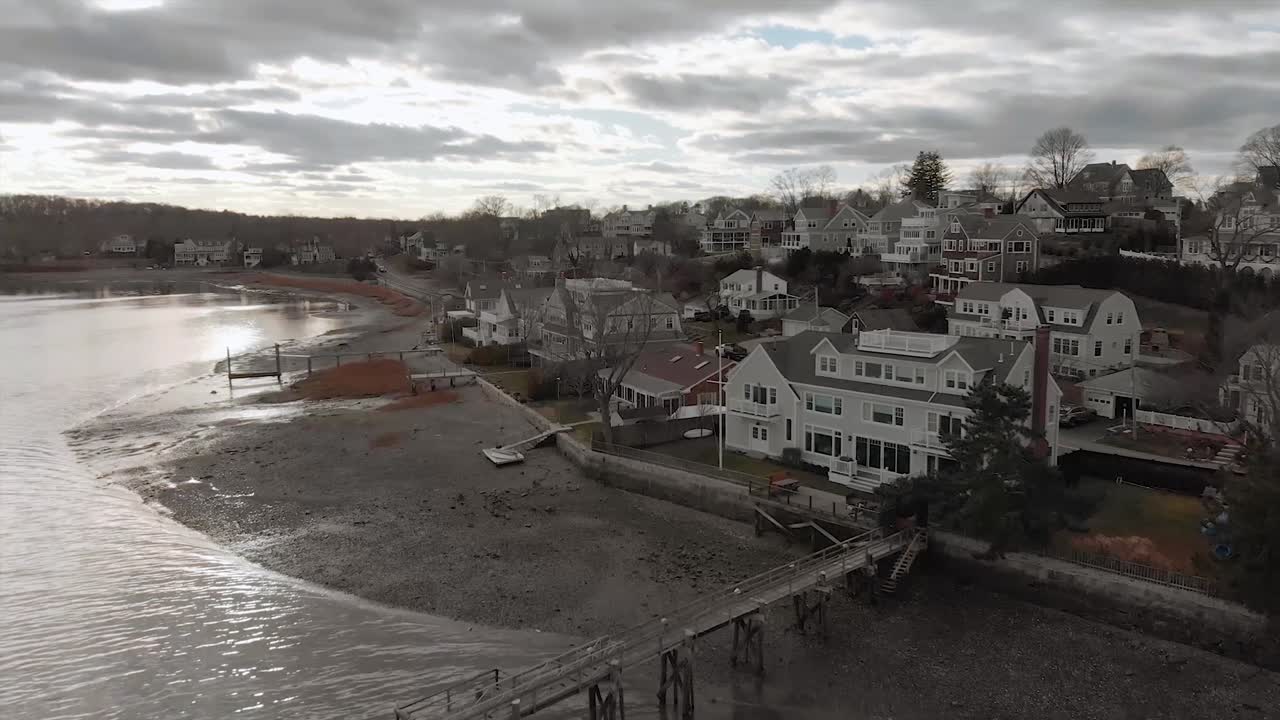 drone volando en un día nublado por el puerto hingham hacia crow point, lujoso pueblo con casas caras en massachusetts - antena