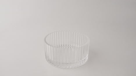 la mano quitando la pizarra dorada de la tapa del soporte de pastel de vidrio, fondo blanco, primer plano