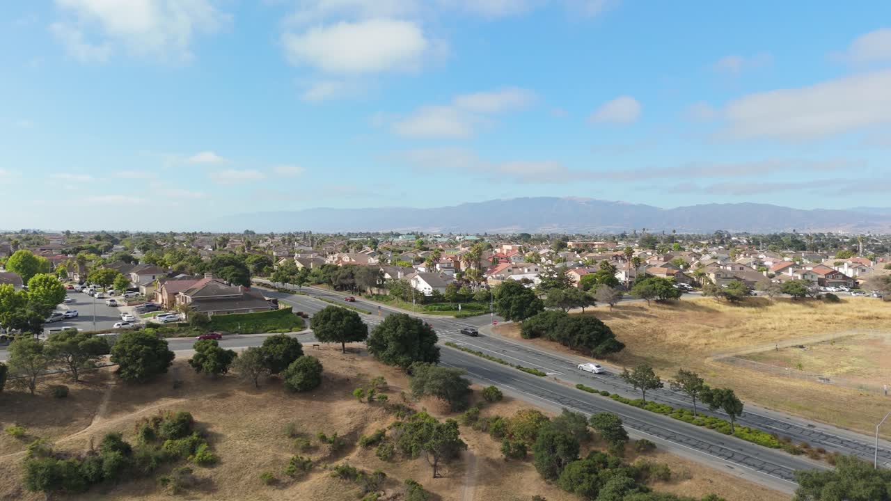 Wide drone establishing of large open space and dry patches within Salinas city park in afternoon light