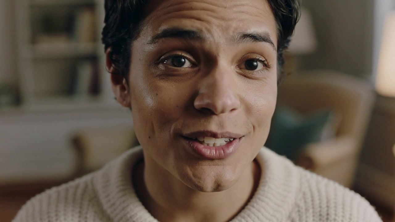 Camera starting recording, man smiling, speaking, addressing camera at home, wearing cream sweater