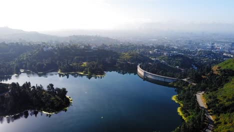 Aerial View of a Reservoir and Dam with Cityscape in the Background