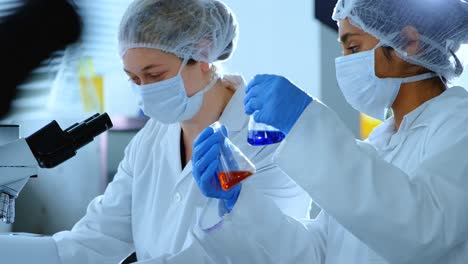 two female scientists experimenting in laboratory 4k