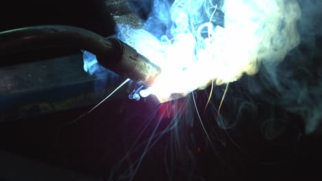 close-up view of metal welding process with sparks and smoke