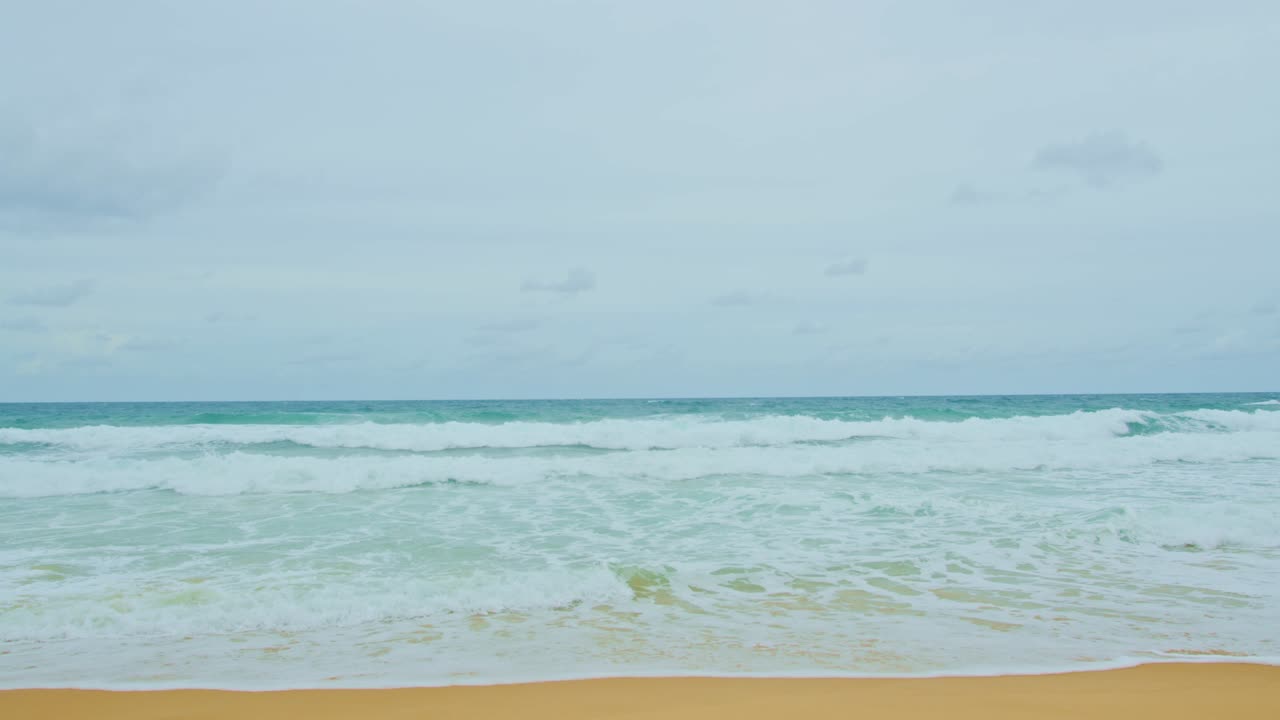 바다의 물결은 푸켓의 하 모래 해변에서 끊임없이 돌아갑니다.