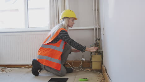 inspector de mujeres con casco y chaqueta de alta visibilidad comprobando el suministro de gas