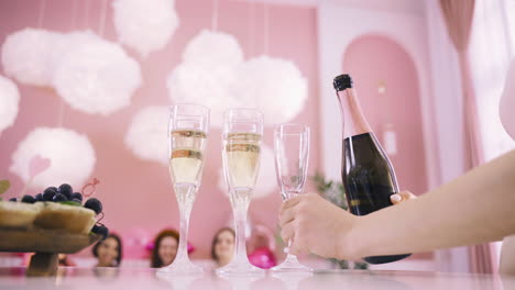 Side-View-Of-A-Woman-Pouring-Champagne-In-Crystal-Glasses-On-The-Table