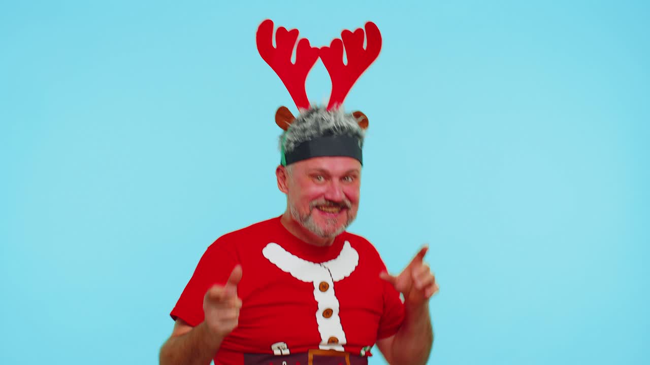 Adult adult man in t-shirt Santa Christmas hat jumps from below dancing fooling around having fun