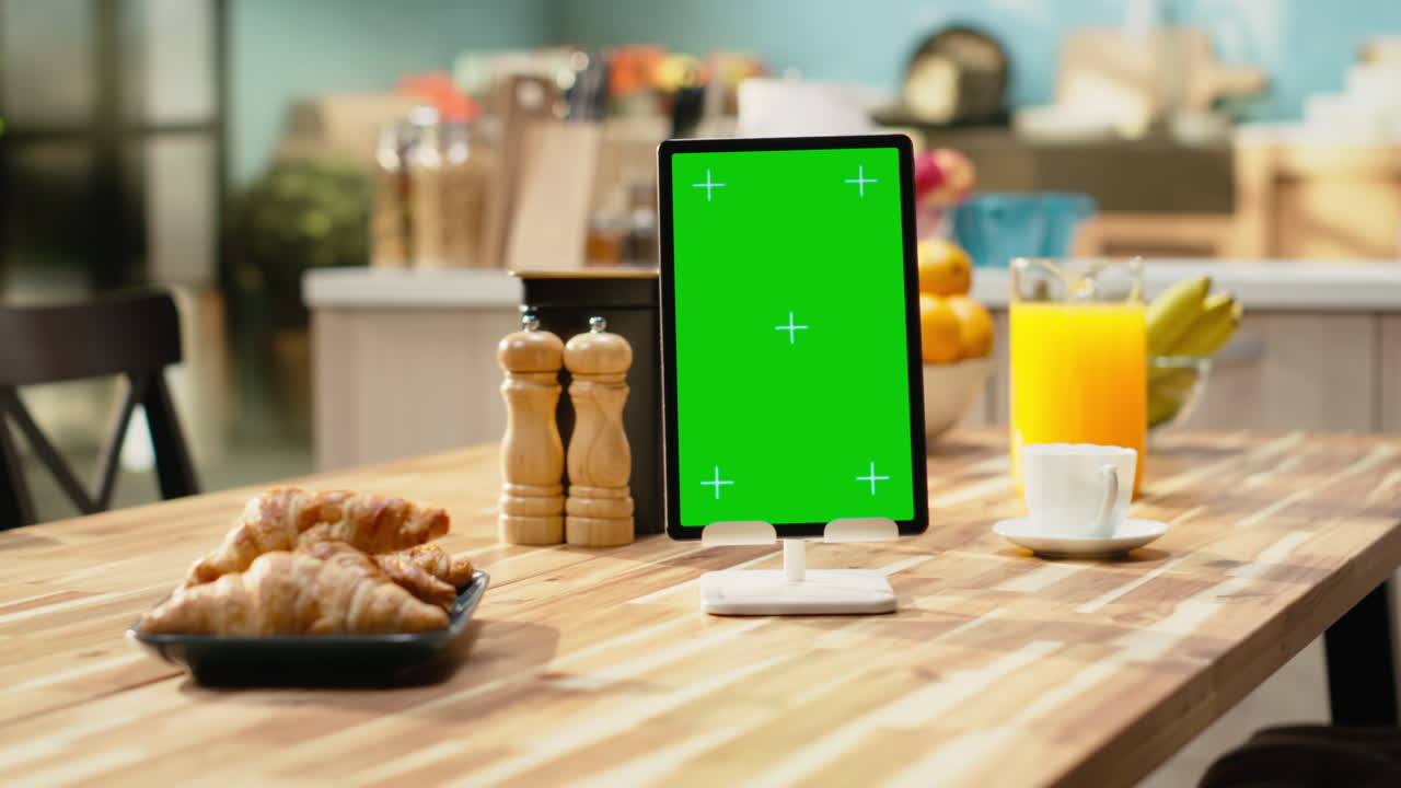 Schermo verde verticale su tablet in una moderna cucina vuota