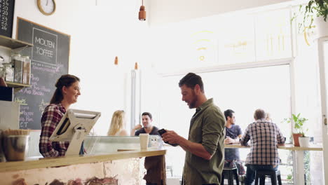 una joven barista que sirve café a un cliente