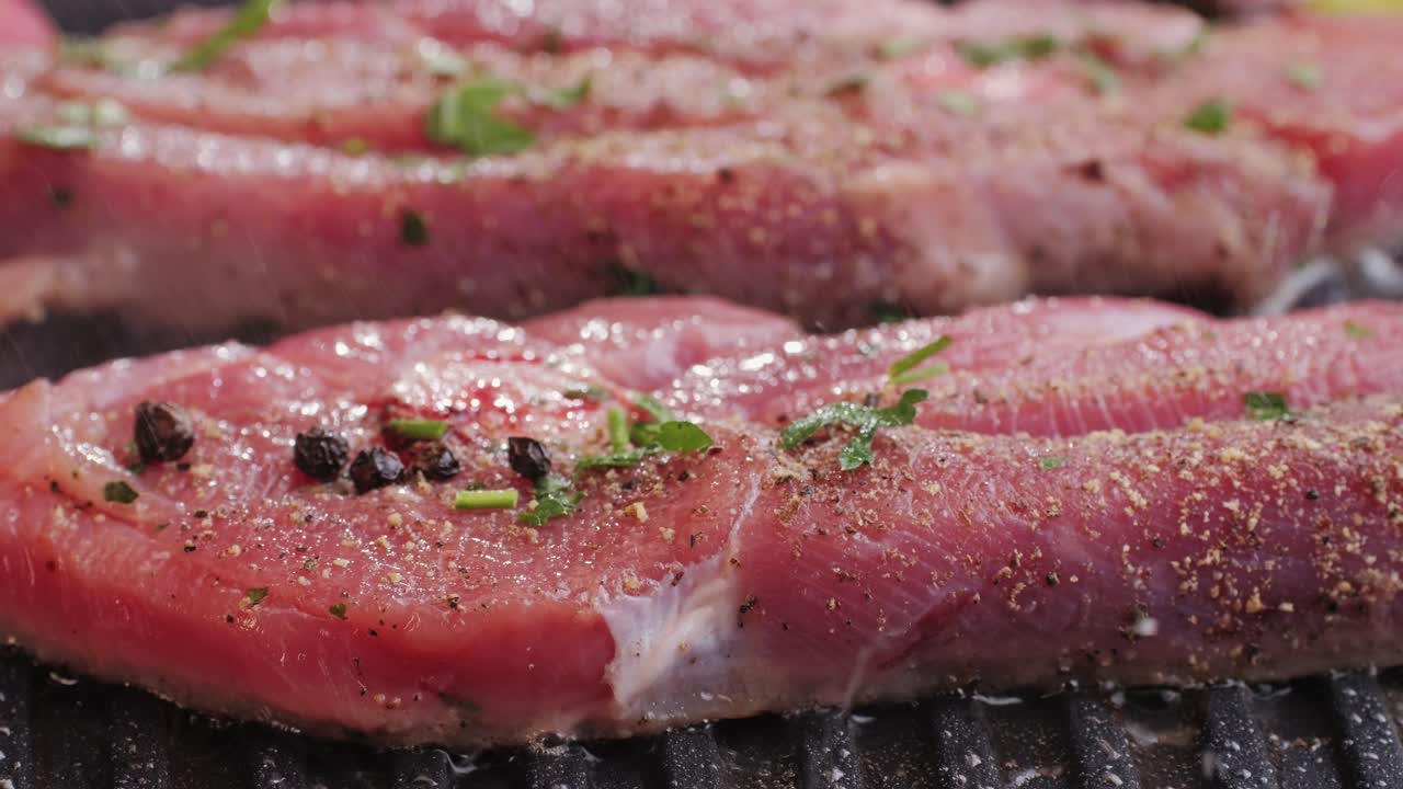 Cooking raw turkey meat in spices with garlic and greens on grill close-up. Fry chicken or turkey slice on frying pan Grilled chicken, duck, turkey kebab with vegetables.