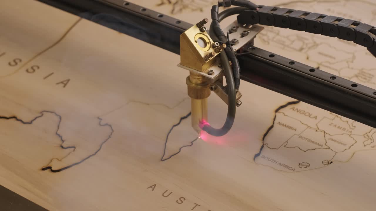 la máquina de corte por láser cnc corta el mapa del mundo en tabla de madera y contrachapado