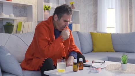 hombre maduro enfermo y perezoso usando su teléfono inteligente en casa, bebiendo bebidas saludables con vitaminas.