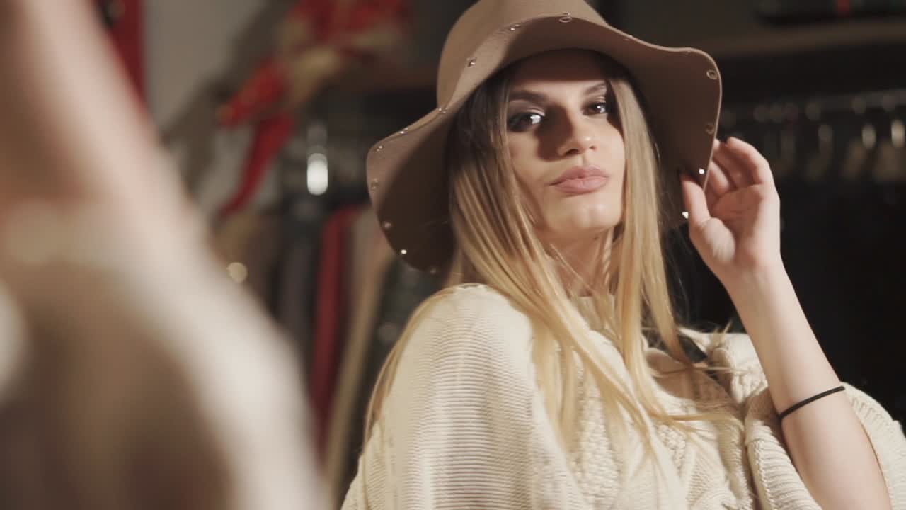 mujer intentando un sombrero en una boutique