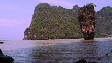 steep wooded cliffs and rock pillar in sea bay of james bond island