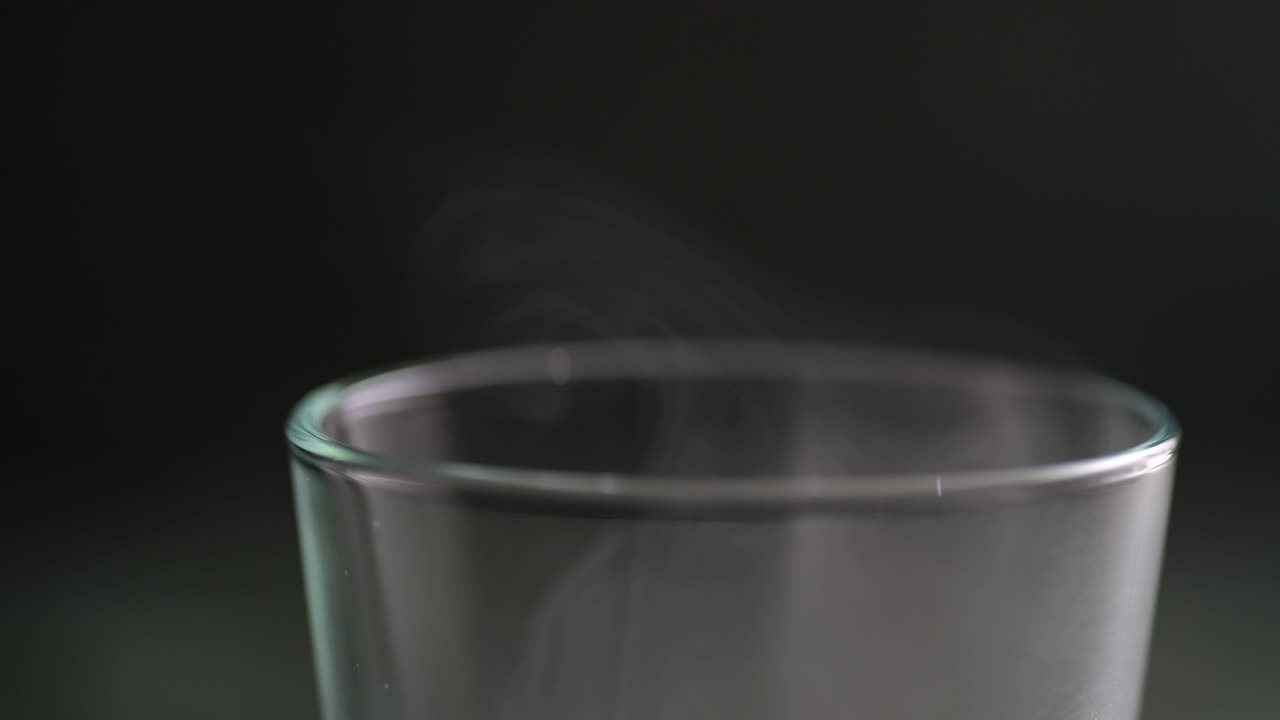 Macro of a lot of flowing smoke over the glass