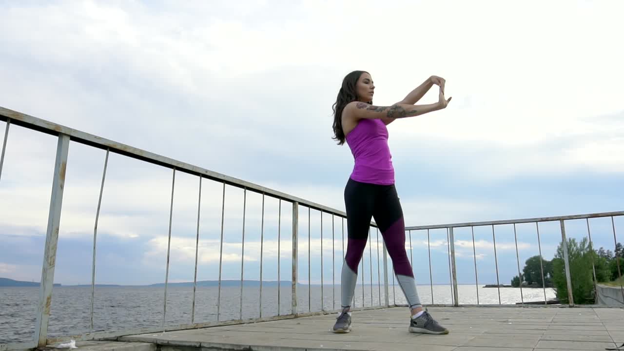 mujer estirándose al aire libre junto al río