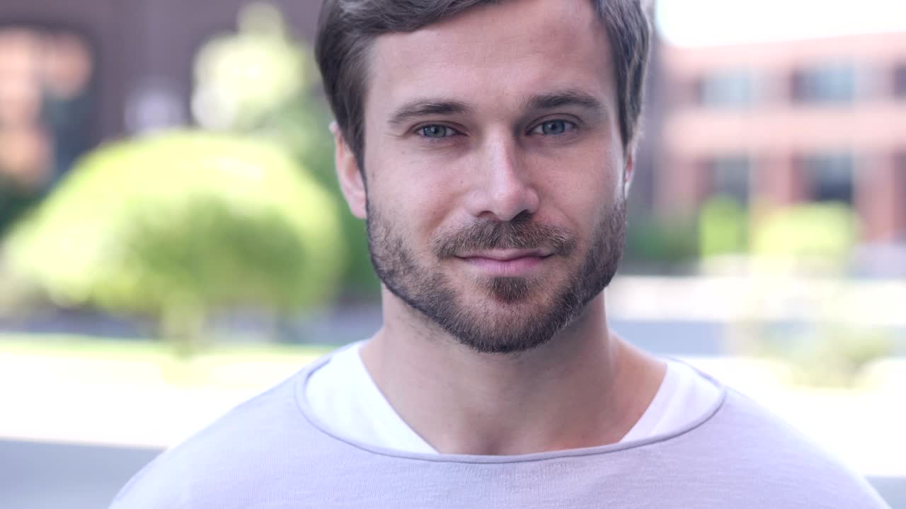 pulgares hacia arriba por el hombre guapo en el trabajo mirando a la cámara