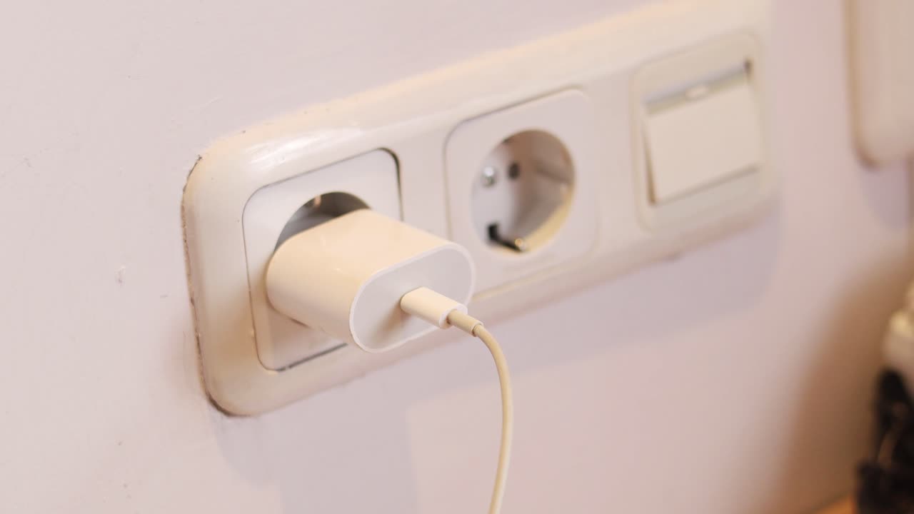White Charger Plugged into Wall Outlet