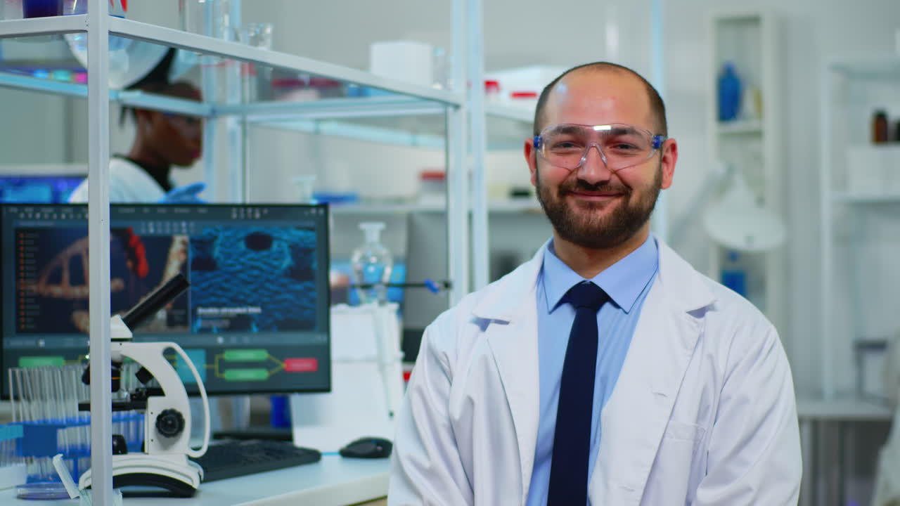 Microbiologist sitting in laboratory looking at camera